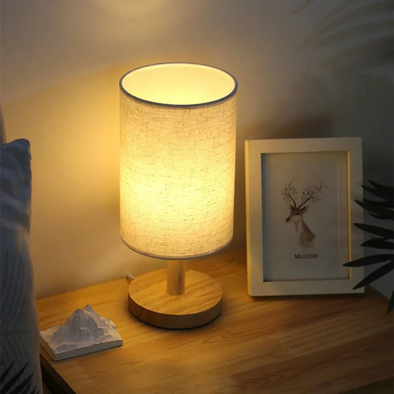 Table lamp on a bedside table with a framed picture and decorative items.