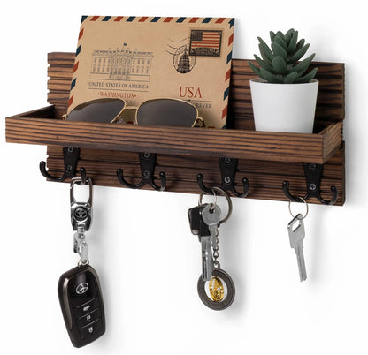 Wooden wall shelf with hooks holding keys, sunglasses, and a plant on a white background