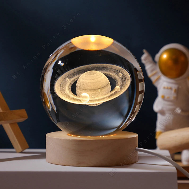 Glass orb with Saturn model on a wooden base, next to an astronaut figure.